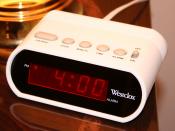 A typical digital 12-hour alarm clock indicating p.m. with a dot to the left of the hour