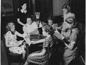 Kathleen Wilson oversees a radio program written and performed by children at radio station , , which was at the time owned by ' newspaper. The photo shows Wilson and girls gathered around a table with a microphone.