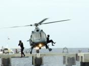 Two coast guards jump out of a helicopter into the sea.
