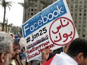 English: A protester holding a placard in Tahrir Square referring to Facebook and Twitter, acknowledging the role played by social media during the 2011 Egyptian Revolution.