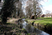 English: Beddington: River Wandle, looking west As the River Wandle runs out of Croydon and into Sutton, it emerges into the open air from the culvert system that has carried it under Croydon. The Wandle here is carrying excess water from Waddon Ponds as 
