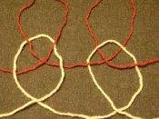 Large-scale illustration of plaited stitches in knitting; each stitch is given one twist, one clockwise and one counterclockwise. Stitches with more twists are possible, but relatively rare, usually in elongated stitches (e.g., Mary Thomas' book on knitti