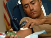 English: OKINAWA, Japan (Nov. 22, 2008) Engineering Aide Constructionman Roberto Diaz, assigned to Naval Mobile Construction Battalion (NMCB) 133, applies pressure to a gauze on his arm after donating blood during a blood drive hosted by NMCB-133 on Camp 