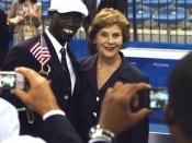 Mrs. Laura Bush with U.S. Flag Bearer Lopez Lomong as she greets members of the U.S. Summer Olympic Team at the Fencing Hall in Beijing on August 8, 2008. Mr. Lomong is a survivor of the violence in his native Sudan. He is now a U.S. citizen and was selec