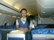 Cabin in a PBair Embraer ERJ 145 LR featuring an air hostess and a steward serving passengers in the air