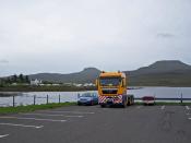 English: Wind farm truck in Dunvegan car park Having delivered a crane to the Edinbane wind farm site, this lorry driver is parked up in the uncrowded Dunvegan village car park for a few nights. Beyond is Loch Dunvegan, with the camp site looking busy. Ma
