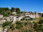 This shows the old northern side of the town of Jaujac in the Ardeche region. The town is built apparently clinging onto the sharp slope.