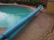 English: A rolled up pool cover used by a residential swimming pool. Photo taken by SMC.