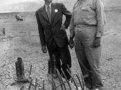 English: In September 1945, many participants returned to the Trinity Test site for news crews. Here Oppenheimer and Groves examine the remains of one the bases of the steel test tower.