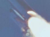 Camera E-207 show a plume near the aft strut that attaches the right solid rocket booster (RSRB) to the external tank. Photo courtesy NASA (Štart raketoplánu Challenger STS-51-L. Kamera zaznamenala plameň šľahajúci z motora SRB)
