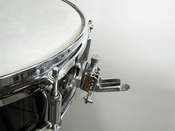 English: Snare drum strainer, used to enable or disable snares on a snare drum. Français : Déclencheur de timbre de caisse claire, permettant d'activier ou de désactiver le timbre d'une caisse claire.