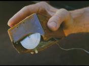The first computer mouse held by Engelbart showing the wheels that directly contact the working surface