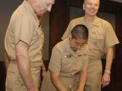 US Navy 040722-N-9693M-005 Chief of Navy Chaplains, Rear Adm. Louis V. Iasiello, left, watches with Commander, Naval Reserve Force, Vice Adm. John Cotton as newly commissioned Ensign Jeanette Gracie Shin signs her Oath of Offic
