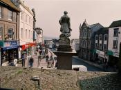 English: Market Jew Street Sir Humphrey Davy turns his back and looks down the main Penzance high street and beyond into distant Carn Brea on the skyline.