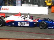 English: TV personality Huell Howser rides as a passenger in a 2-seat Indy Racing League open-wheel race car at the 2009 Long beach Gran Prix.