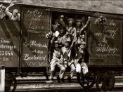 English: German soldiers, some with flowers others waving or rasing their clenched fists, in a railroad car on the way to the front during early World War I (1914). Messages on the car spell out (approximately): 