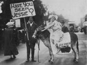 English: Young girl riding a donkey, possibly during a Labor Day procession in Brisbane, ca. 1928 The donkey is draped in a banner with the name Jessie Sevanston printed on it. A man stands next to the donkey holding a placard that reads: 'Have you seen J