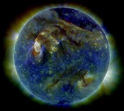 The Sun shows a C3-class solar flare (white area on upper left), a solar tsunami (wave-like structure, upper right) and multiple filaments of magnetism lifting off the stellar surface.