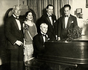 English: Birthday party honoring Maurice Ravel, New York City, March 8, 1928. From left: Oscar Fried, conductor; Eva Gauthier, singer; Ravel at piano; Manoah Leide-Tedesco, composer-conductor; and composer George Gershwin.
