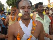 English: Hindu devotee with garland of marigolds around his neck, a trident piercing two lemons and his cheeks. Original caption: "Pierced for Peace" A devotee participating in a religious procession with his cheeks pierced with a sharp trident 