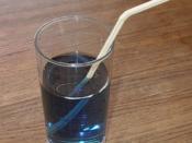 A photo showing refraction of light rays: a soda straw sticking out of a glass of water. It looks broken.