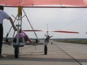 Complex control: The kited hang glider pilot is the main decision maker; the ultralight tug pilot has control duties. Hang glider on a runway, ready to start by UL-tow. The kite hang glider is sitting in a three-wheeled trolley while the trike is starting