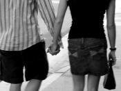 English: A male and a female holding hands.