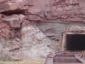 English: A Uranium mine, near Moab. Note alternating red and white/green sandstone and mudstone. This color variation corresponds to oxidized and reduced conditions in groundwater fluid redox chemistry. The rock forms in oxidizing conditions, and starts w
