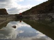 English: quarry. Part of quarry at Spittal filled with water, pump in background working overtime to pump water away.