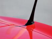 Abstract Photo of radio antenna on a red convertible car