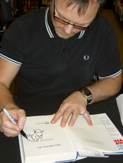 English: Cartoonist Simon Donald drawing Sid the Sexist on a copy of his book Him off the Viz, at a book-signing at Waterstones in Leeds, 19 November 2010. That copy of the book belongs to the uploader.
