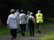 English: Walking for Health in Epsom, England. A group of walkers are following the walk leader, who is wearing a yellow jacket.