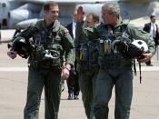 President George W. Bush walks across the tarmac with NFO Lt. Ryan Phillips to Navy One, an S-3B Viking jet, at Naval Air Station North Island in San Diego Thursday, May 1, 2003. Flying to the USS Abraham Lincoln, the President will address the nation and