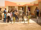 English: Soldiers interact with children outside of a new school built in the city of Khalkalan in Kirkuk province, Iraq, during the school's opening ceremony, Sept. 14. The school can accommodate 500 children and is the first school built in this communi