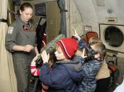 US Navy 110330-N-ZK021-009 Naval Air Crewman 2nd Class Jennifer Brawning explains functions of in-flight survival gear to children