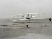 First flight of the Wright Flyer I, December 17, 1903, Orville piloting, Wilbur running at wingtip.