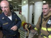 US Navy 060526-N-9851B-007 Engineering Training Team (ETT) leader, Master Chief Engineman Kevin Colligan, discusses the performance of fire teams involved with fighting a simulated fire in the number two auxiliary machine room