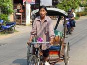 English: A woman pedals a rickshaw in Khon Kaen, Thailand. She was 49 years old when this photo was taken, and had been driving a rickshaw for 20 years. She estimates there are about 300 rickshaw drivers in the city, and believes she is the only woman amo