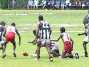 Action from the 2005 TIFL Grand Final between Pumarali (red and white) and Muluwurri (black and white).