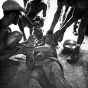 English: A wounded Vietminh prisoner is given first aid by Franco Vietnamese medicals after hot fire fight near Hung Yen, south of Hanoi. Ca. 1954 (USIA)
