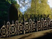Sloping grave with robust iron fence