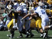Falcons defensive linemen hit Cowboys running back Alvester Alexander in the backfield for a loss during the Air Force-Wyoming game in Laramie, Wyoming. Air Force's defense held Wyoming to 240 overall yards in the 20-14 victory.
