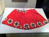 Swimsuit made in 1950 by Mrs. Fleta L. Calicutt of Randolph County NC from and uncut bolt of fabric used to make Hitler Youth armbands brought back as a war souvenir by her infratry husband who had served in Europe. Using the fabric in a swimsuit was inte
