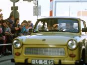 West German children applaud as an East German couple drive through Checkpoint Charlie and take advantage of relaxed travel restrictions to visit West Germany.