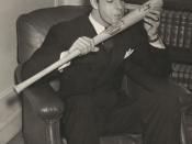 Photograph shows Joe DiMaggio, of the New York Yankees, wearing suit, sitting in a chair, facing slightly right, about to kiss his signature baseball bat.