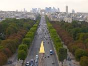 Perspective des Champs-Elysées, de la place de la Concorde à l'Arc de triomphe, vue aérienne prise de la grande roue. Pointe dorée de l'obélisque en premier plan. Les arbres près de l'avenue sont taillés au carré, les arbres dérrière poussent librement.Au