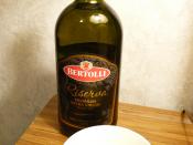 A 1-liter glass bottle and bowl Bertolli brand Riserva Premium extra virgin olive oil. Olive oil from Italy, Greece, Spain, and Tunisia, and bottled and packed in Italy. Olive oil purchased in a Stow, Ohio store. Photographed in Kent, Ohio, United States.