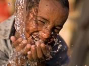 English: child enjoying clean and safe drinking water from a newly built well, funded by charity: water