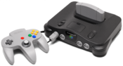 English: A Nintendo 64 video game console shown with gray controller. This is the PNG version. Français : Une console de jeu vidéo Nitendo 64 avec une commande grise.