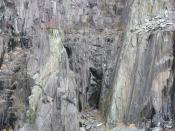 English: Igneous intrusions into the slate rock at Vivian Quarry The green and red layers are igneous material intruded into the metamorphosed sedimentary rocks during the transformation process which converted mudstone into slate. The igneous material is